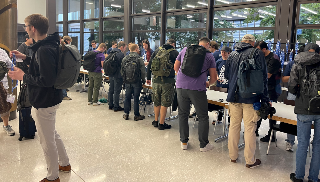 group of people lined up in front of registration desk