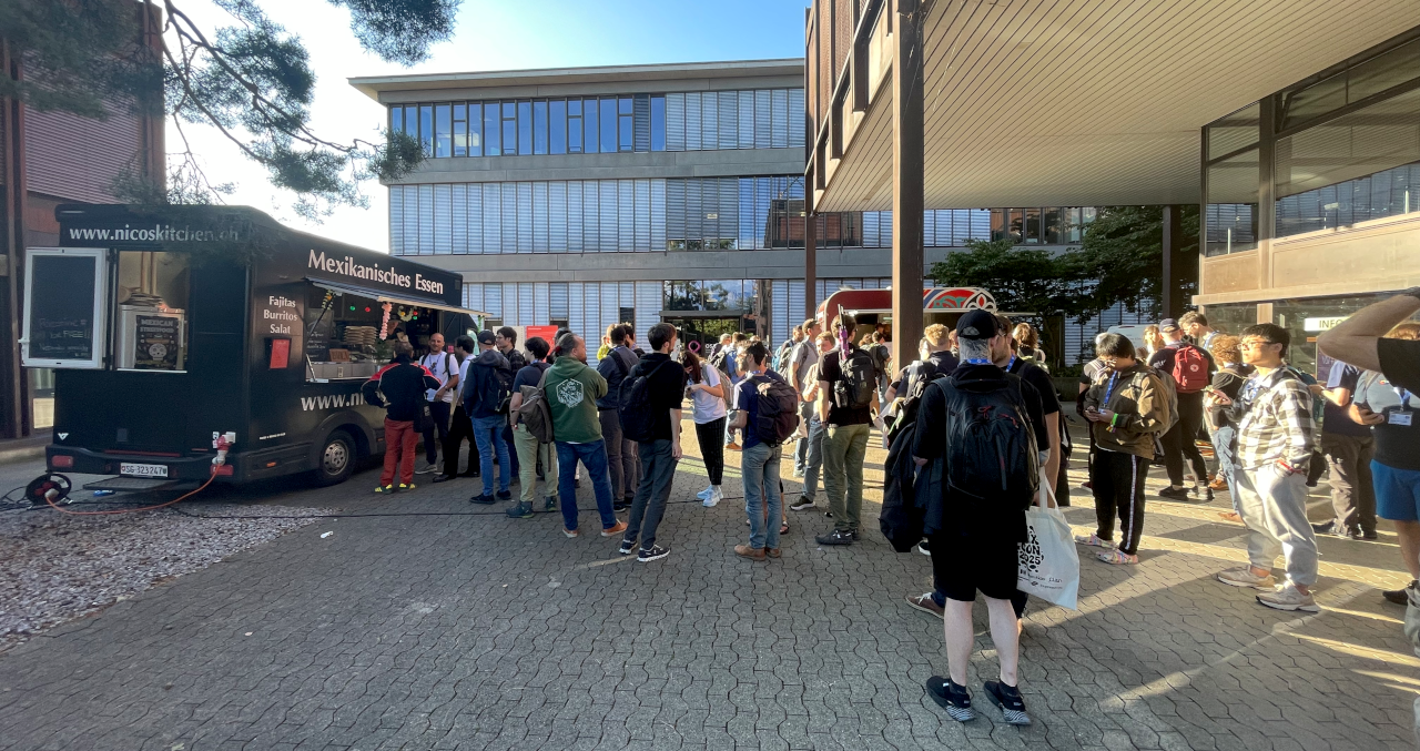 a crowd in front of food and beer trucks